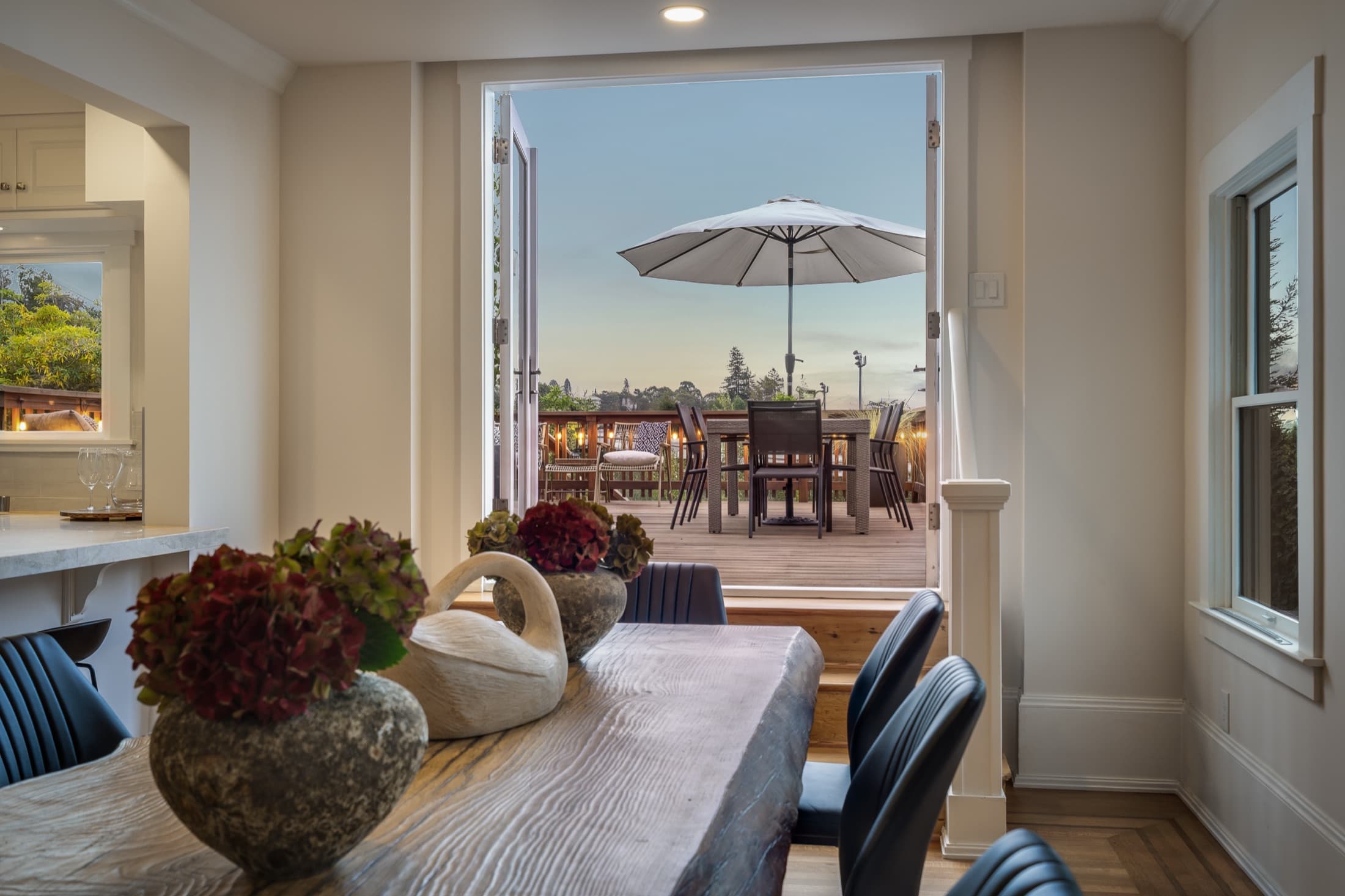 The dining room opening to the deck at dusk.